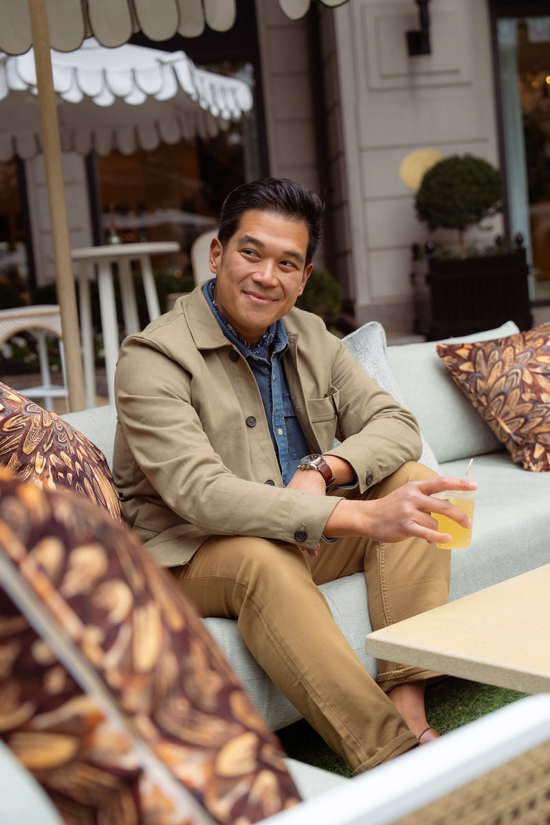 Man sitting on outdoor couch with drink in hand